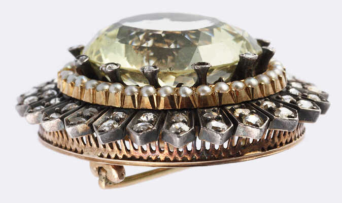 Брошь из желтого и белого металла, общим весом 29,1 грамма, содержит природные вставки